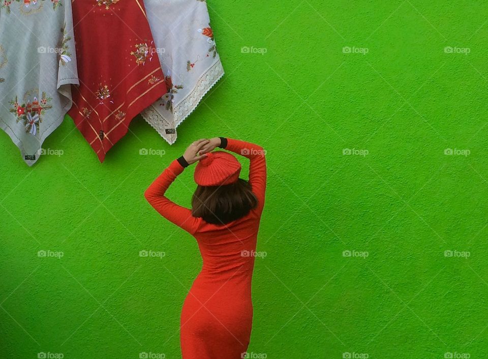 Lady in orange and green wall on background 