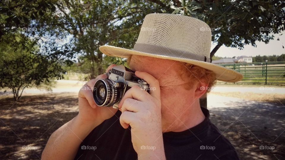 Summer Shot of a man in a Straw Hat with a Camera & Lots of Sunshine