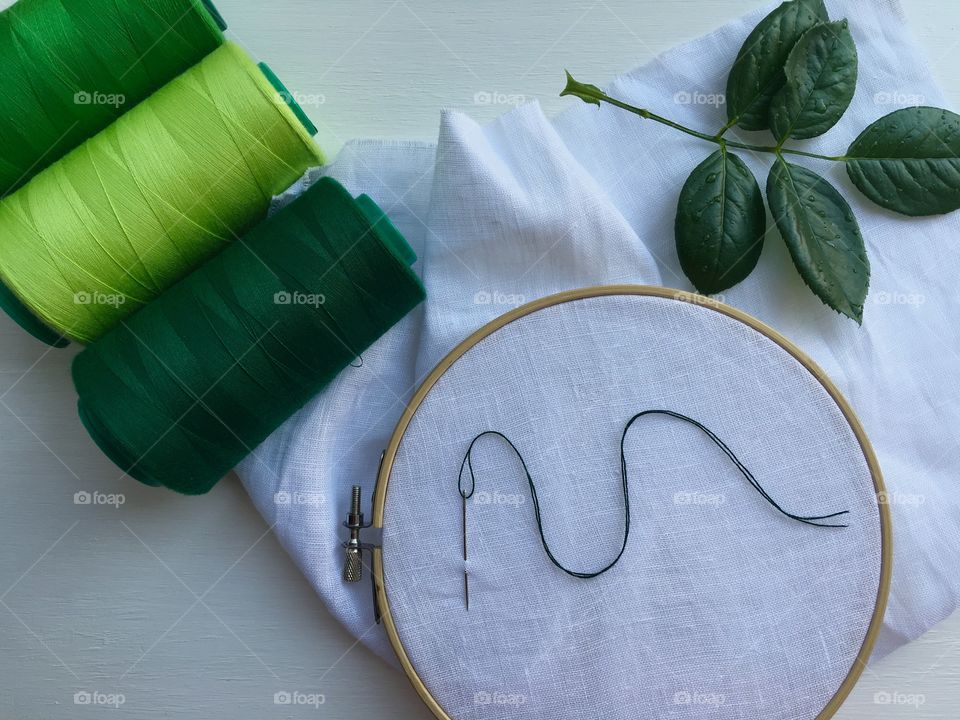 Set the green thread in the bobbin and canvas in the wooden hoop for sewing and embroidery
