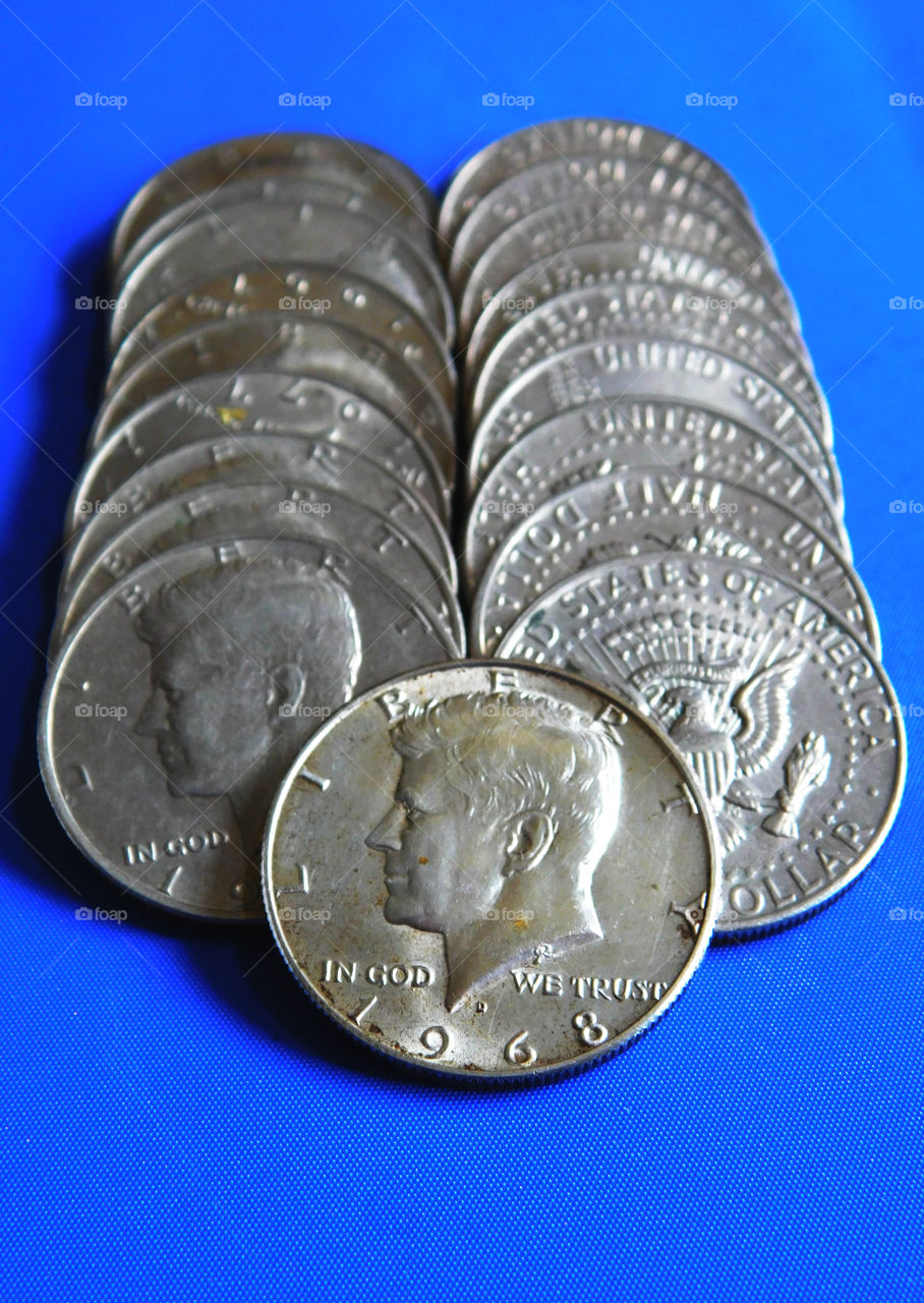 Heap of American dollar coin on blue background