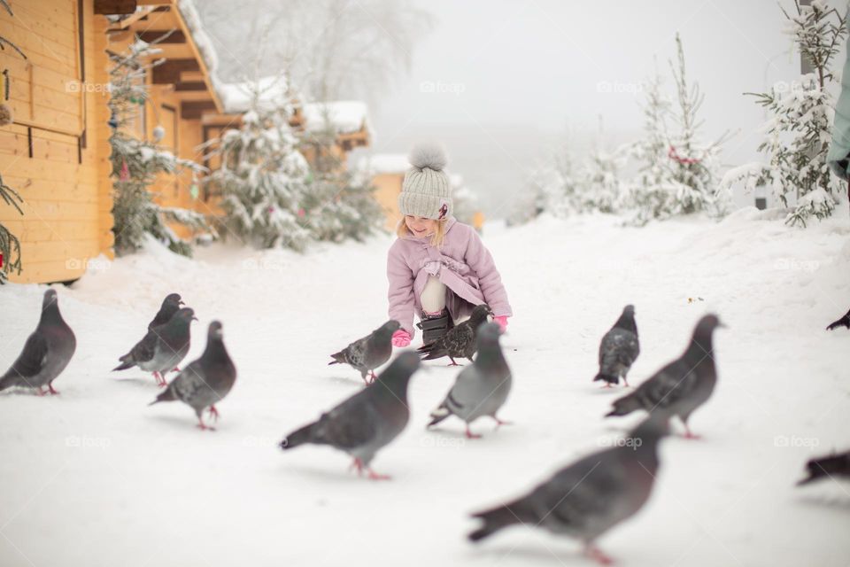 girl feeding pigeons