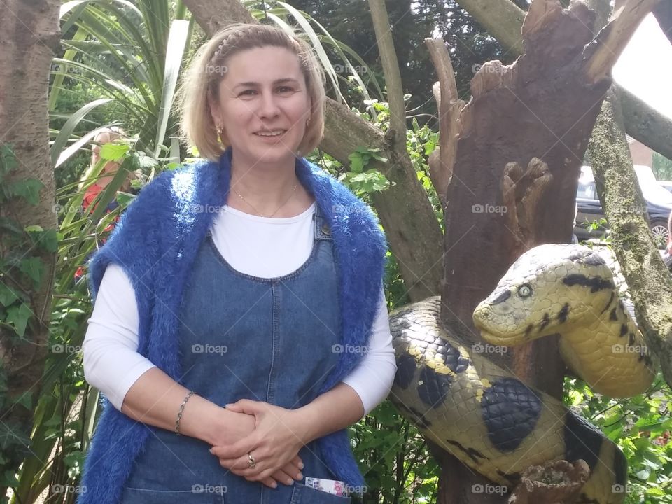 Mature woman posing near the snake statue