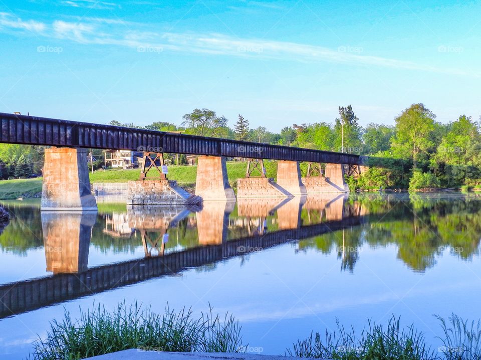 A train bridge over the Grande River with a nice reflection.