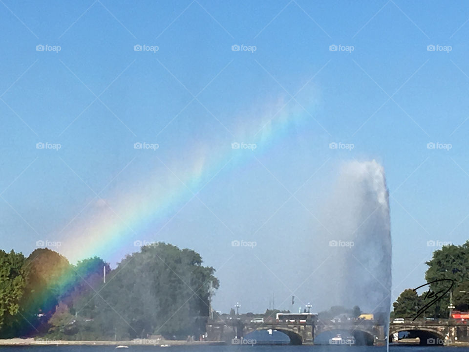 Rainbow caused by fountain at Alster in Hamburg, Germany,