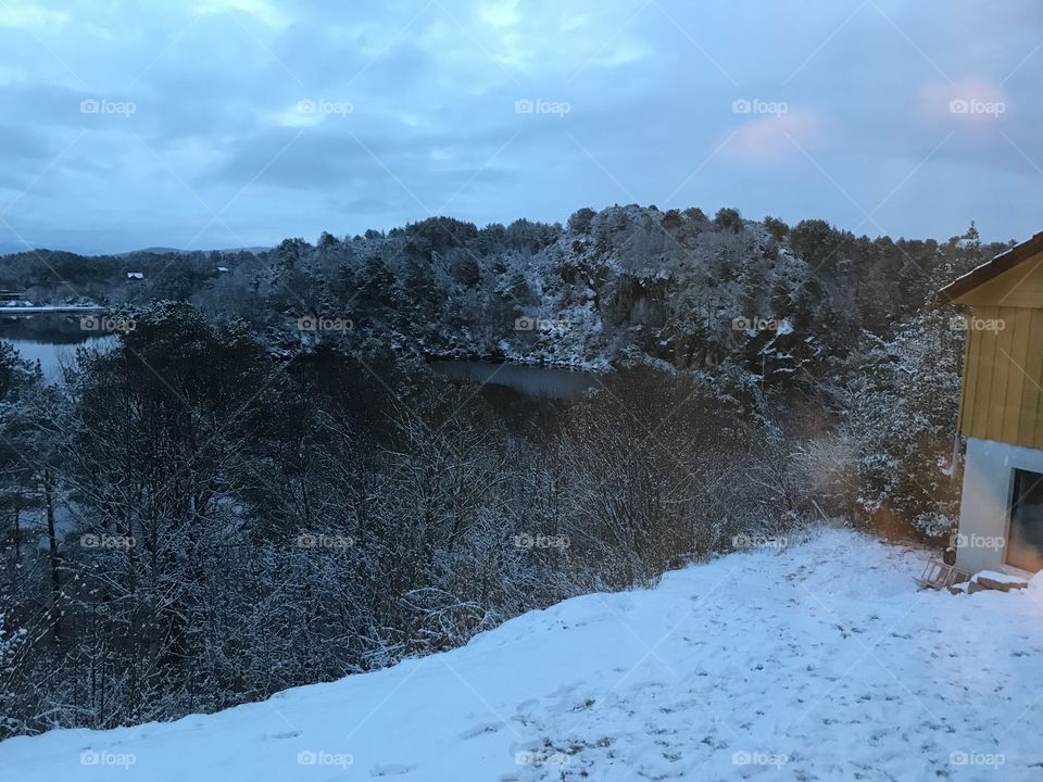 The evening is approaching as the white snow is starting to melt away after the winter. The weather is clear, some skies. Taken in Norway.