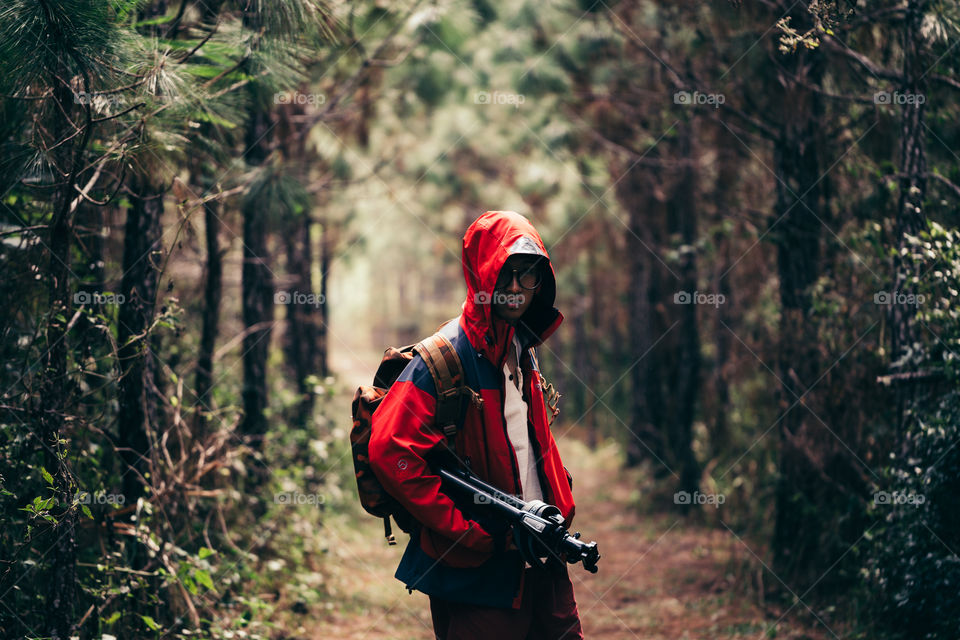 Photographer in red suit in the forest 