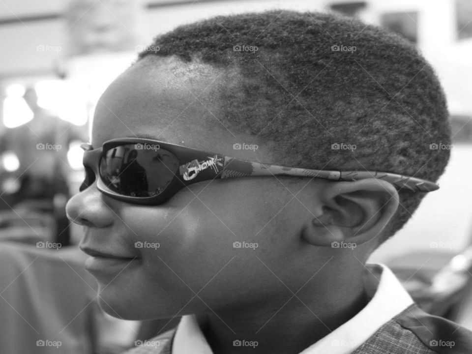 Young child taking a profile picture in black and white to show off his new sporty sun glasses