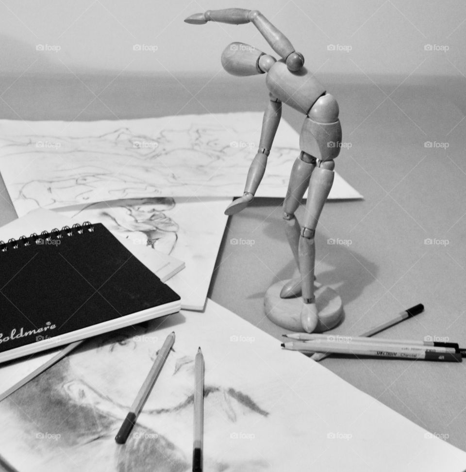 Posable figure for life drawing, with various sketches, pencils, book and paper. 
