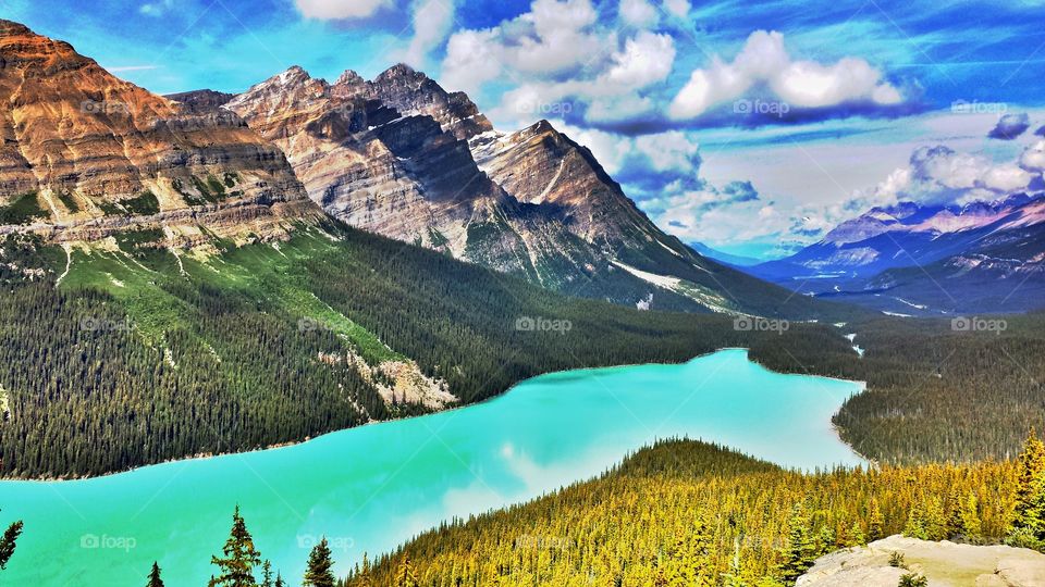 Blue lake with mountains. This is Peyton lake in Banff Canada. The mountains in the background hover over this beautiful lake.