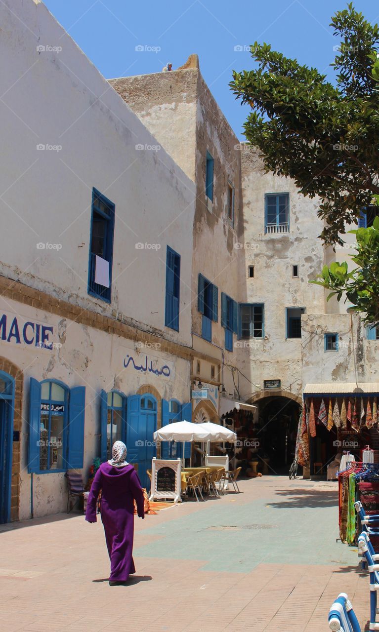 A woman walks through a square in Essaouira 