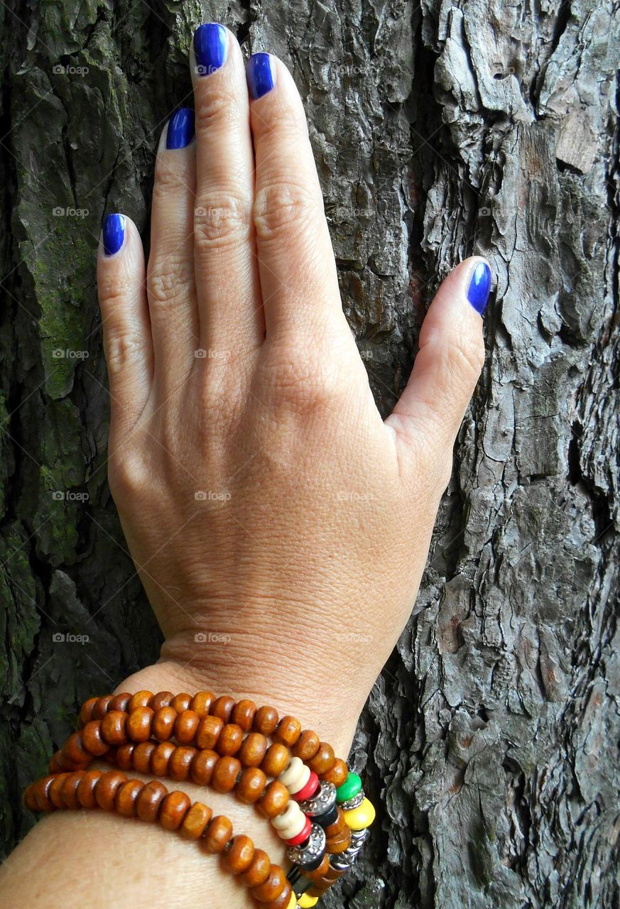 wooden bracelet on a female hand wooden background