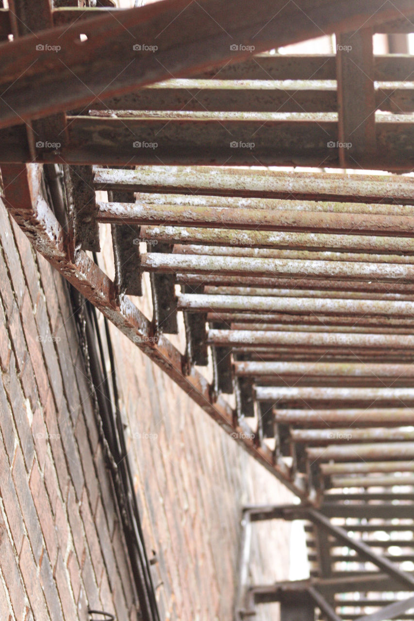 Rustic metal brown steps going up the side of building