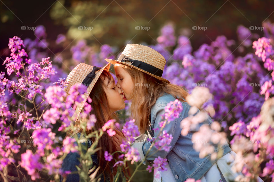 Little sisters in a blossom meadow 