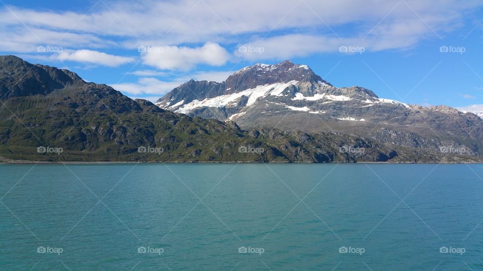 Mountain glacier and Ocean view on bright blue sky sunny day from cruise ship in Alaska