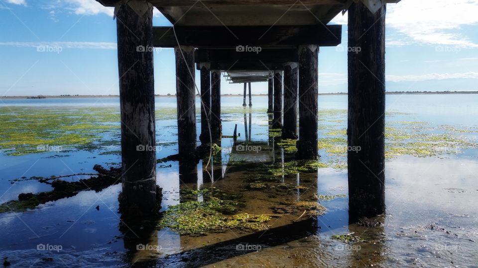 Reflections over the Pacific Ocean from under  a dock 
