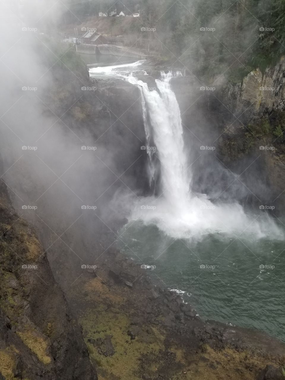 This is a picturesque view of the beautiful Snoqualmie Falls with mist rising up from the floor of the waterfall.