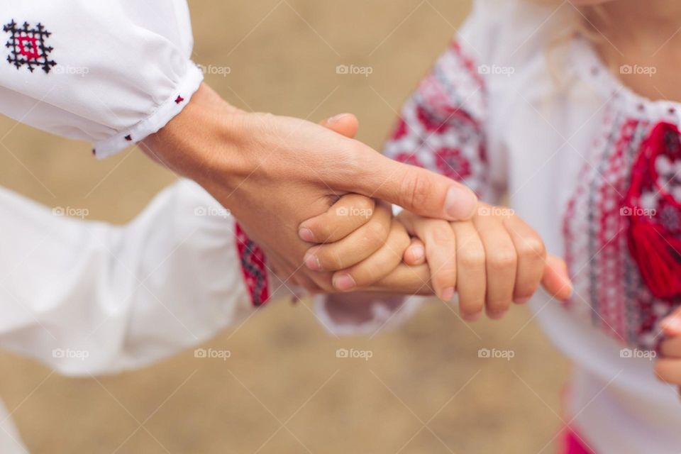 mother, son and daughter holding hands! family in white shirts with embroidery