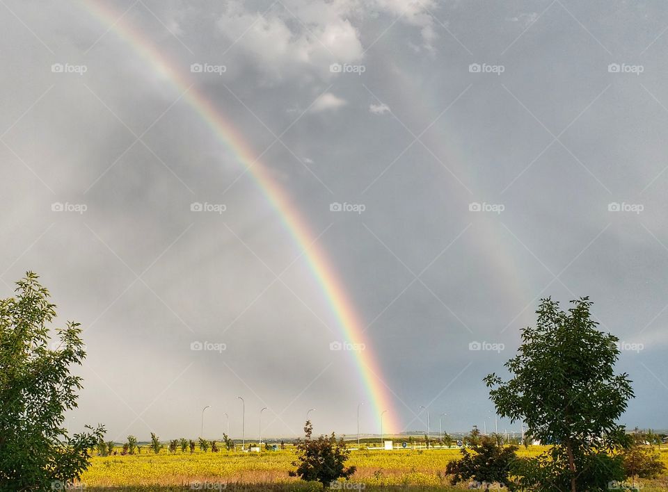 Double rainbow over golden fall farmers fields