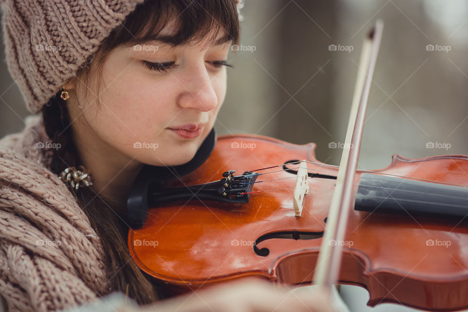 Teenage girl portrait with violin in winter park