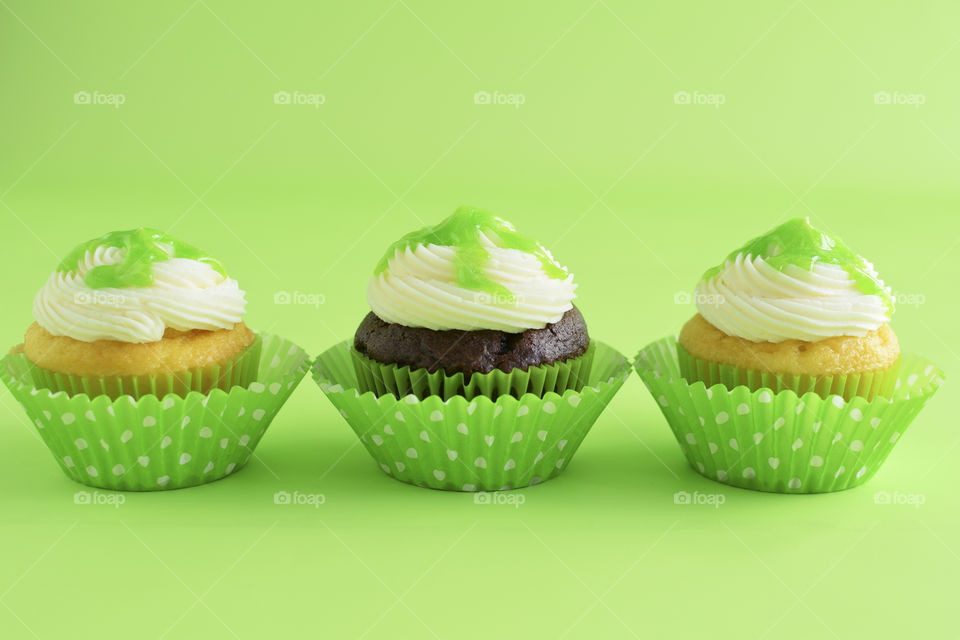 Three Cupcakes in a Row with Green Background 