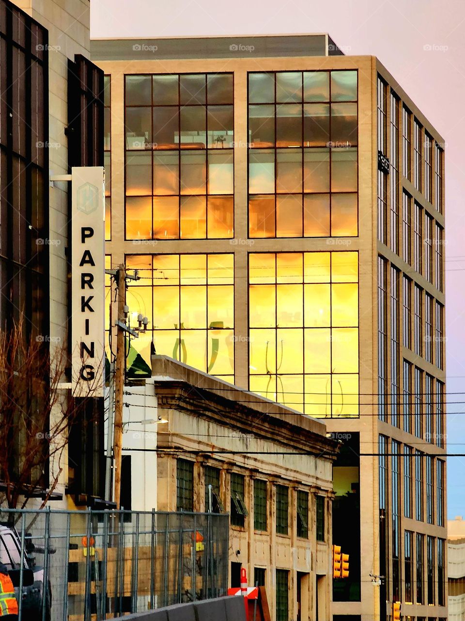 A magnificent golden sunset is reflected in the glass of a relatively mundane building