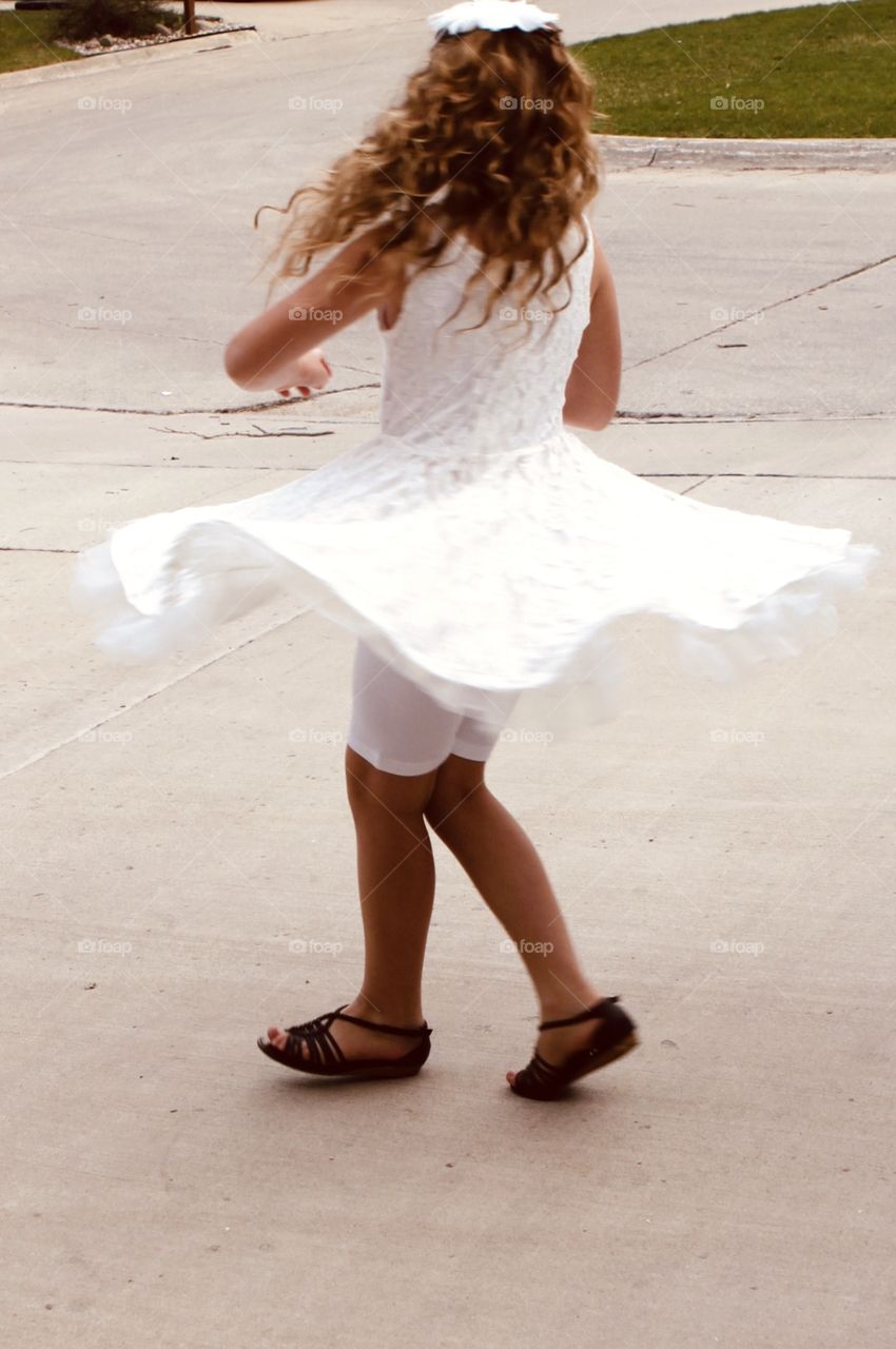 Darling little girl spinning in beautiful flowing white dress and cute brown sandals!! 