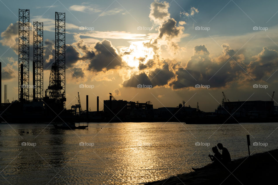 Couple sitting by the bay watching the sunset