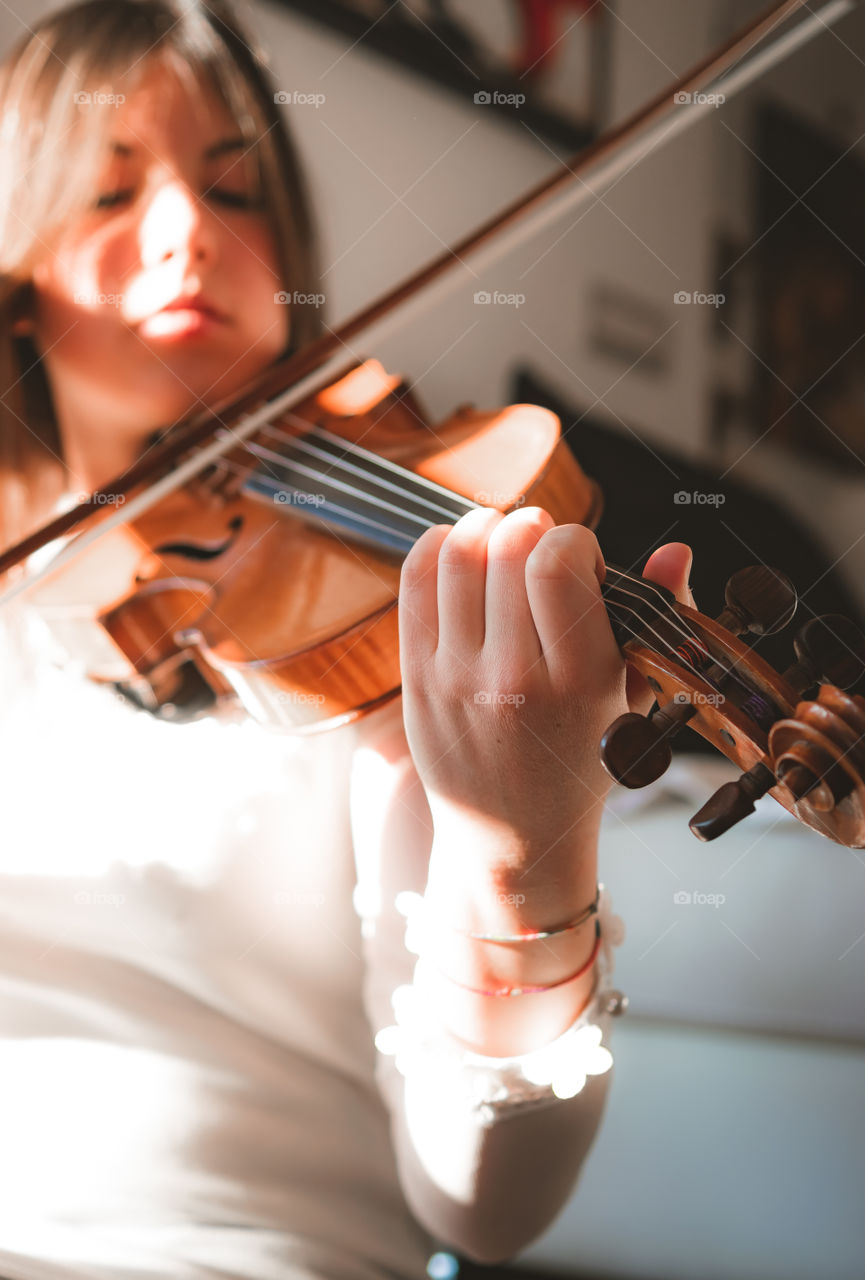 A girl play the violin in the house