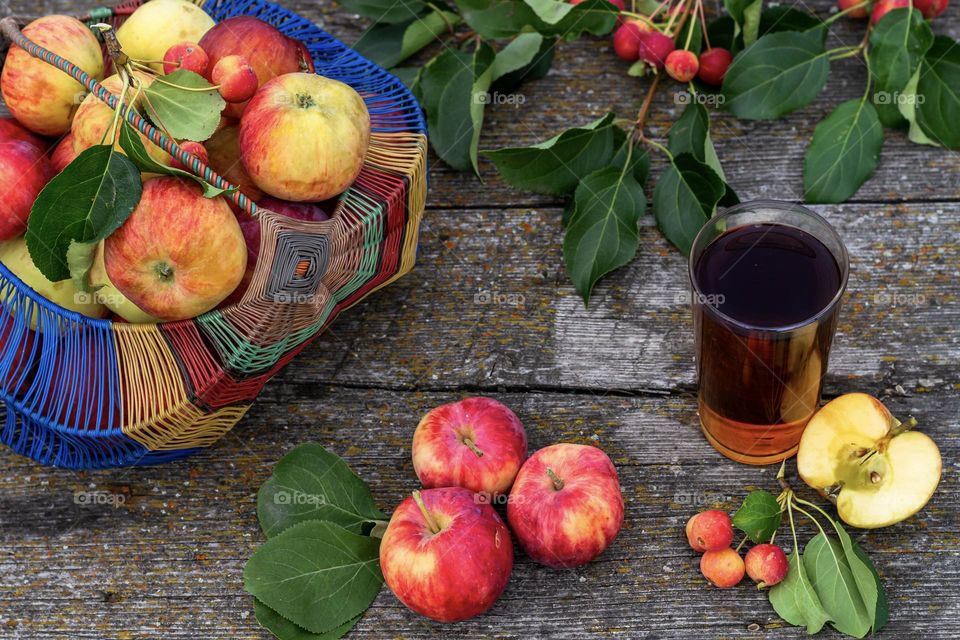 Food still life in a rustic style freshly squeezed apple juice in a glass and orchard apples on a wooden background