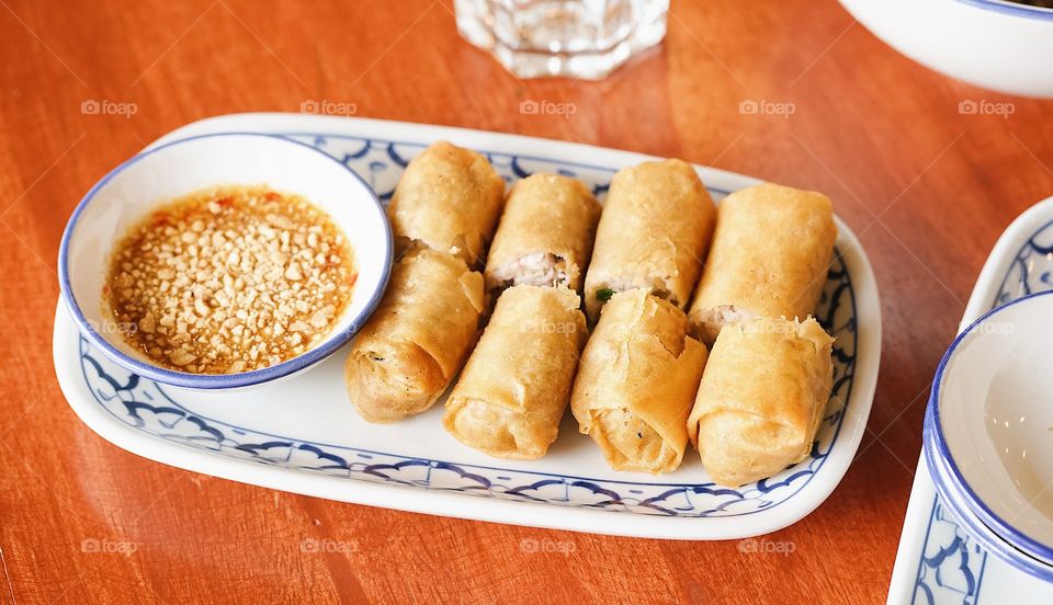 Spring rolls. Thai gourmet spring rolls served as starter on the wooden table.