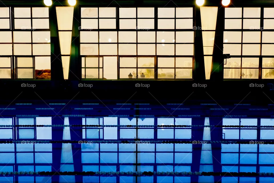 Reflection of the windows in a public pool during sun down. 