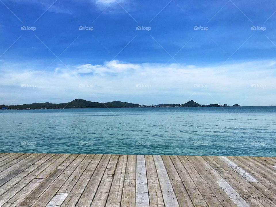 Empty top of wooden table and view of tropical beach for product display. 