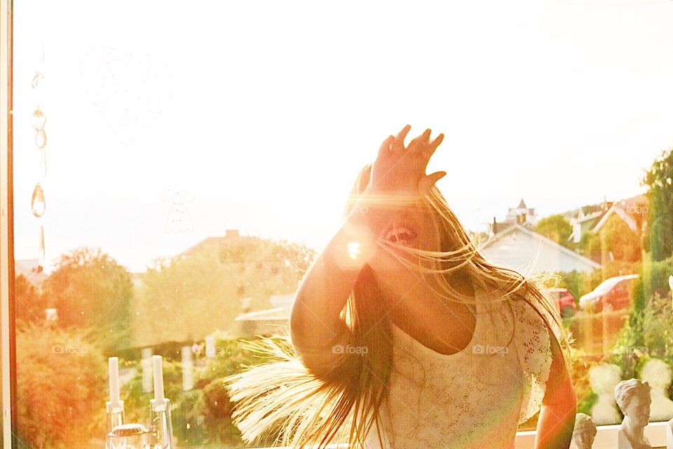 Girl in sunshine dancing with her beautiful blonde hair 