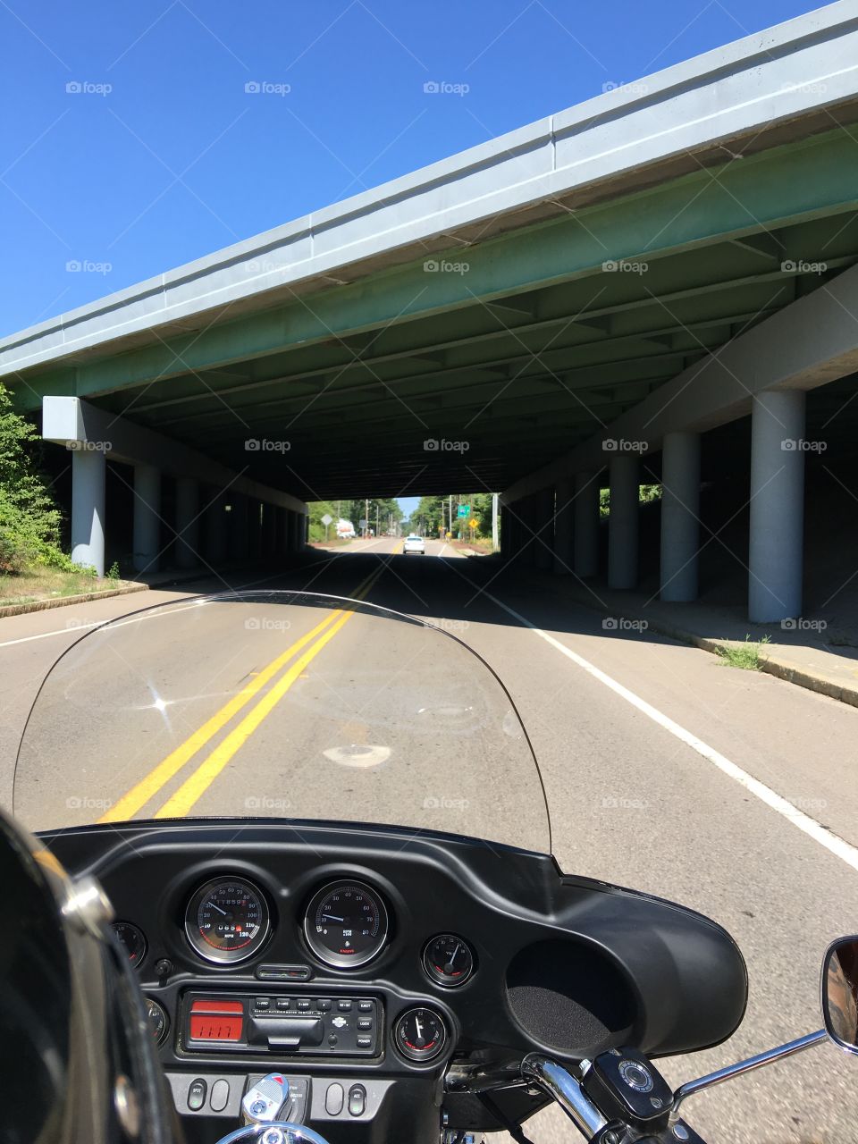 Motorcycle near overpass bridge.