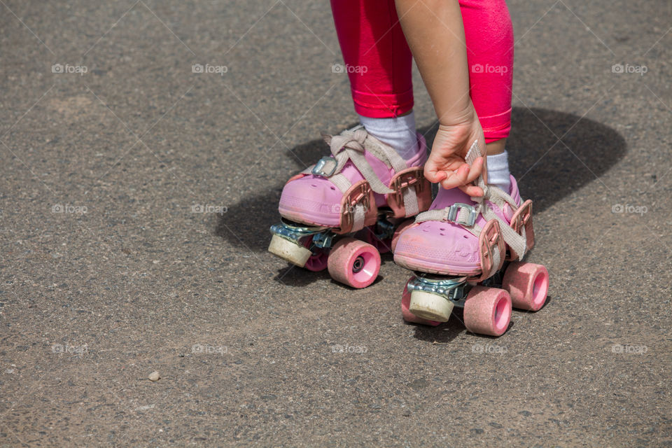 Girl putting on pink skates