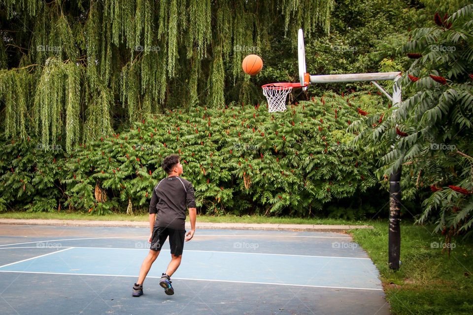 Teenage boy is playing basketball