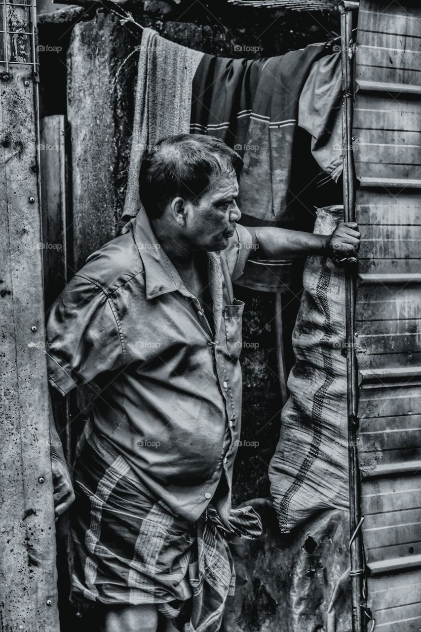 Portrait of old indian man standing near the door
