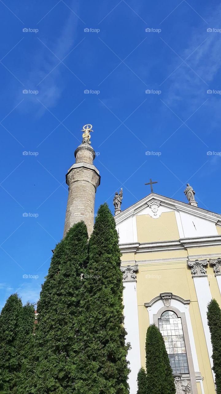 The central facade of the Cathedral of St. Peter and Paul and a minaret with a golden statue of the Madonna Kamyanets-Podilsky  Ukraine