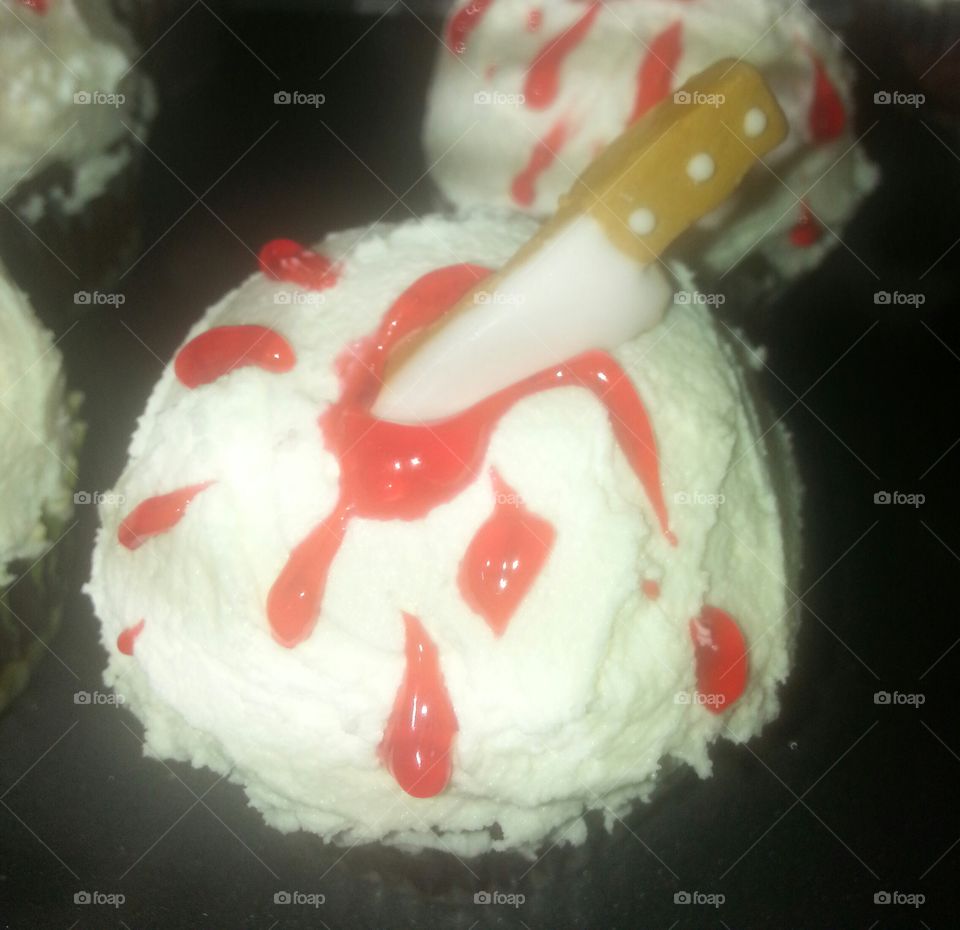 Psychopath cupcakes. Every Halloween, I make these vanilla cupcakes for a charity bake sale. The "blood" is from a tube of red edible gel from my grocer. The knives are edible, and come in packages of 12. I purchase them at Joanne Fabrics.