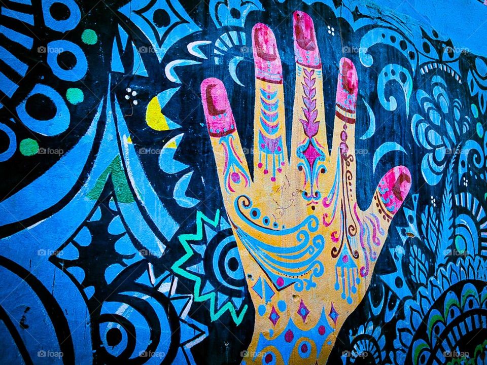 Nubian wall art. A drawing on a traditional Nubian house featuring a colourful hand palm, and henna hand art designs. Nubian Village, Aswan, Egypt.