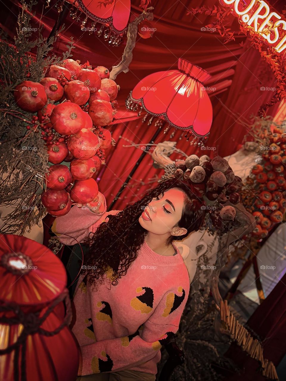 Curly-haired girl and clusters of pomegranates