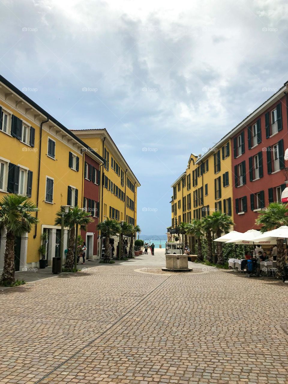 Yellow and red buildings in Sirmione Italy palm tree