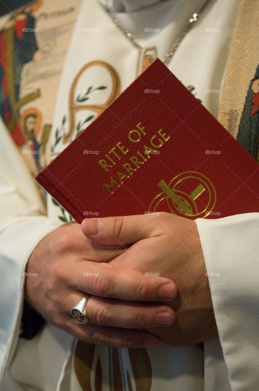 Priest holding rite of marriage book