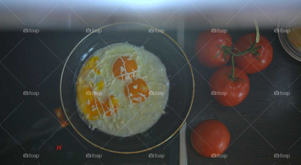 fried eggs with tomatoes cooking and eating home