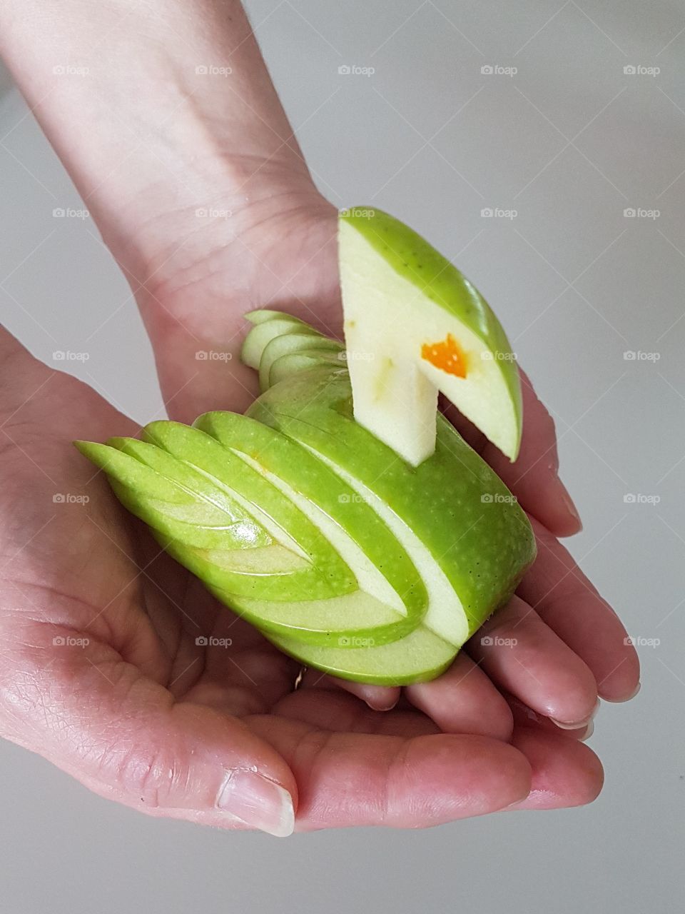 Person holding slices of apple