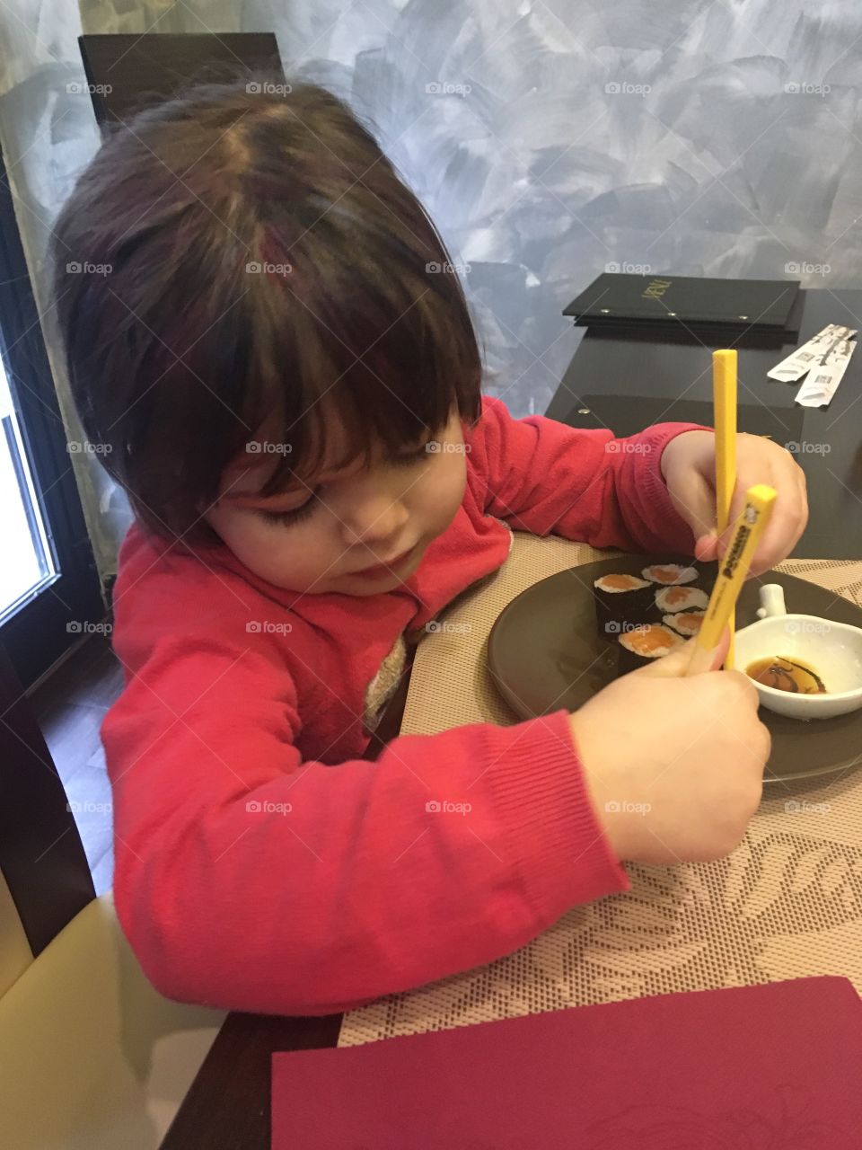 Girl eating sushi chopsticks pink toddler baby child Japanese food restaurant 