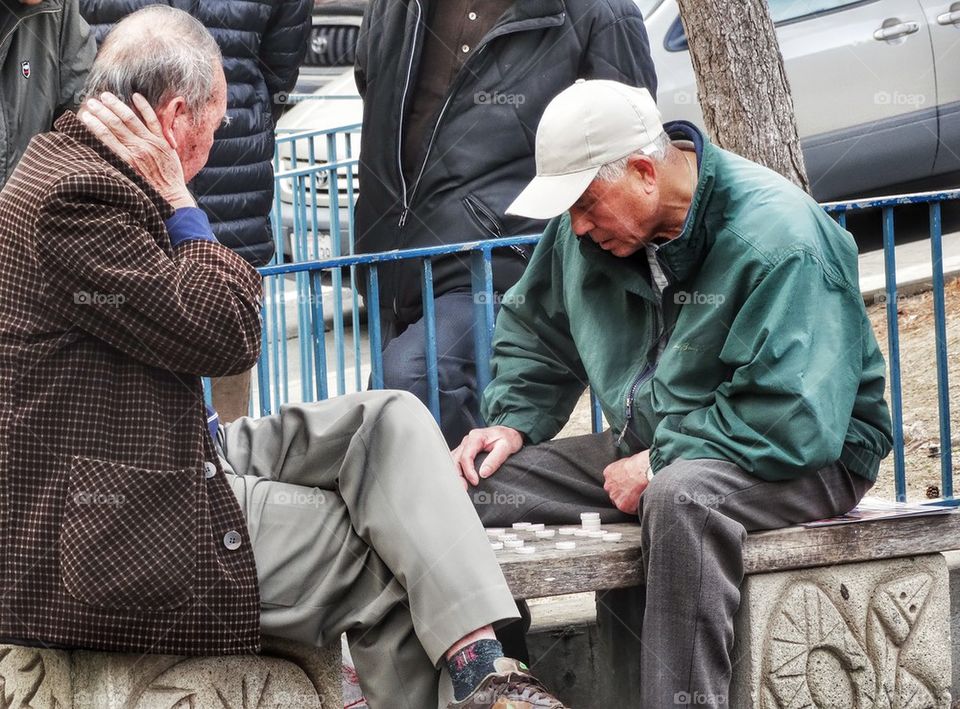 Old Men Playing Traditional Chinese Chess. Men Playing Chinese Chess In A Park
