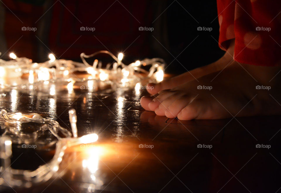 child feet with christmas lights