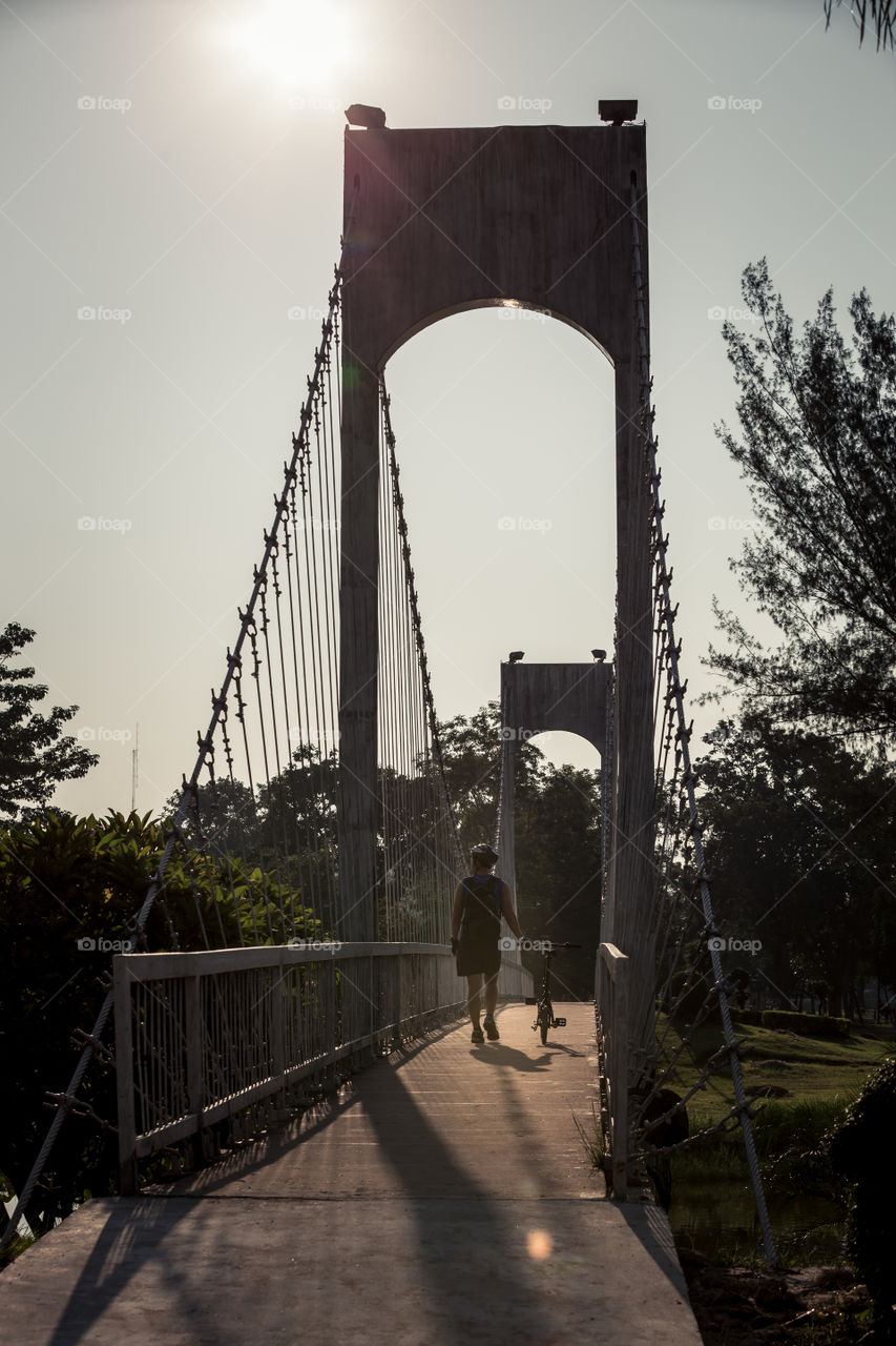 Man with bicycle crossing the bridge