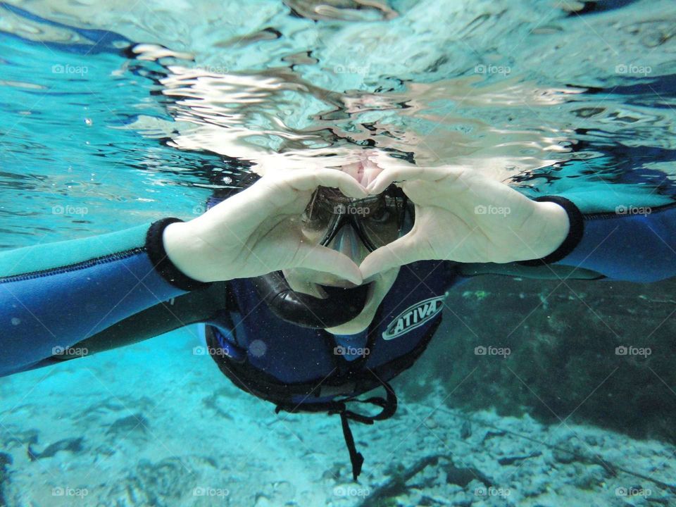 Man making heart shape while snorkeling in sea